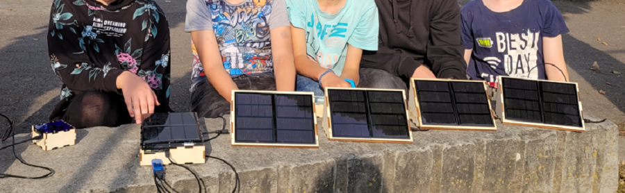 Man sieht 5 Kinderarme, die je eine selbst gemacht Solar-Powerbank in die Kamera halten.